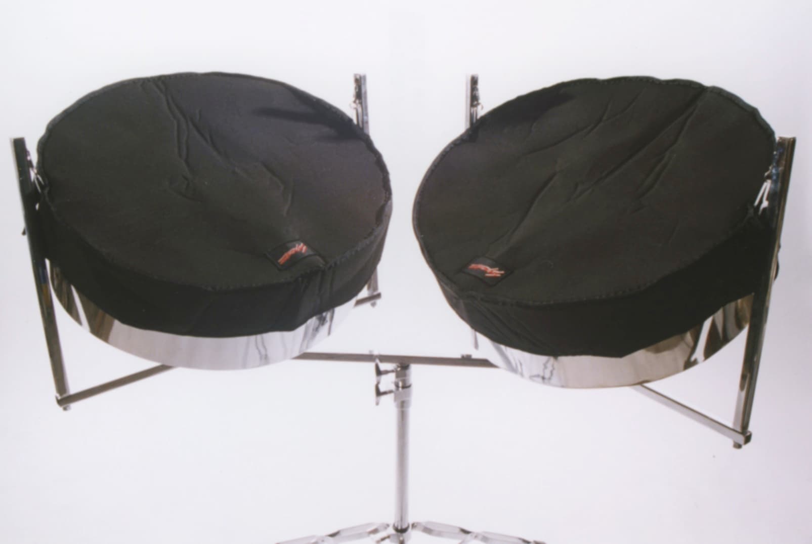 A double tenor steel drum set with protective covers, ready for service